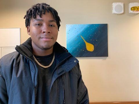 Jae Scott next to his painting An Imperfect Star