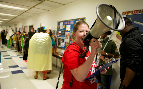 a student talks into a megaphone in a hallway full of people