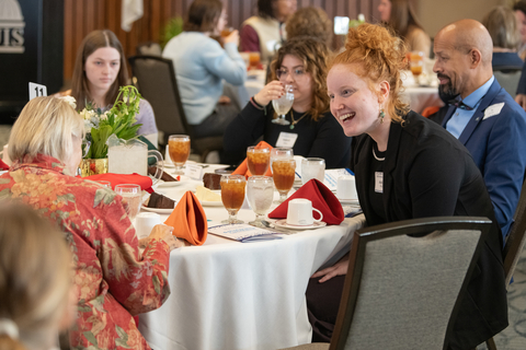 a student smiles while speaking with their scholarship donor