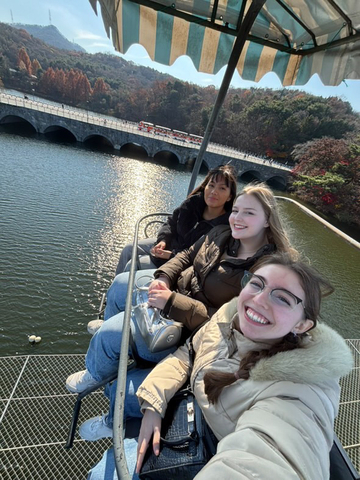 Friends sitting above a body of water.