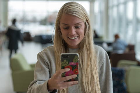 a student smiles while looking at her phone