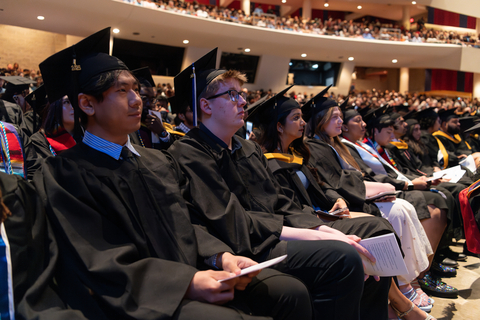 graduates in crowd watching commencement