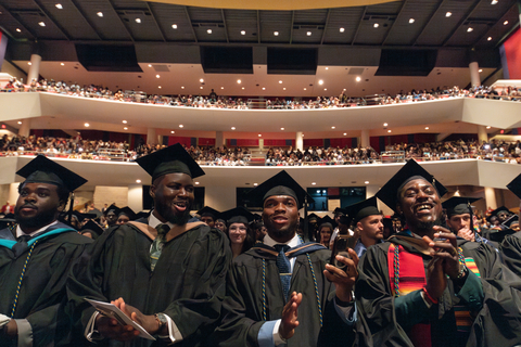 male graduates watching commencement