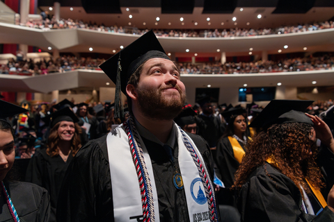 male graduate watching commencement