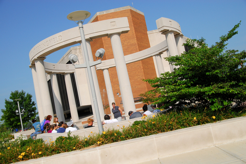 UIS colonnade with students sitting around it