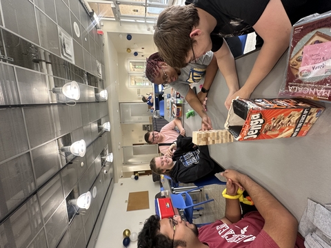 Multiple people around a table playing a game.