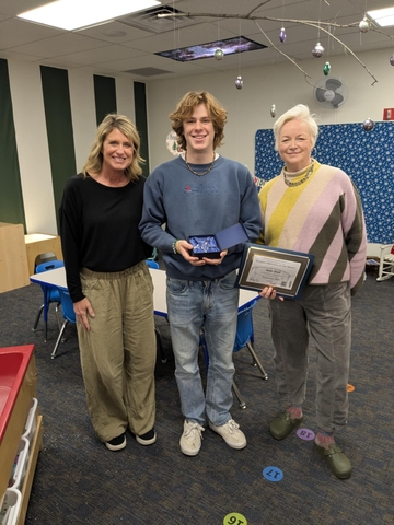 Student receiving award from two staff members.