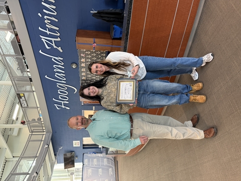 Student receiving award from supervisors.