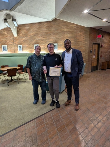 Jonah holding award from Dr. Clark and supervisor.