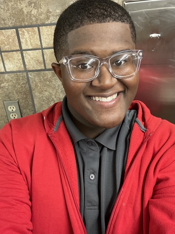 student posed in front of a tiled background