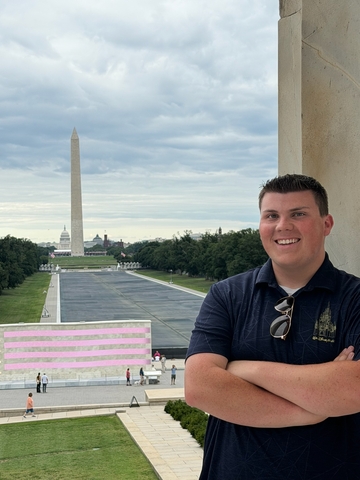 student posed in front of the Washington monument in the background