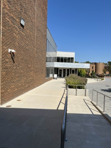 Paved walkway that leads to double doors.