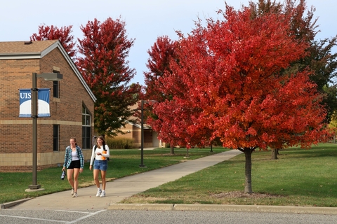 two students walking through the quad during the fall