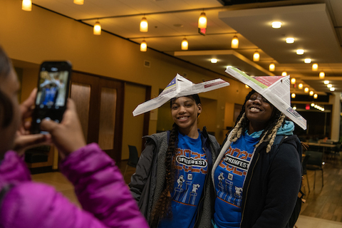 Students posing for a picture wearing silly hats.