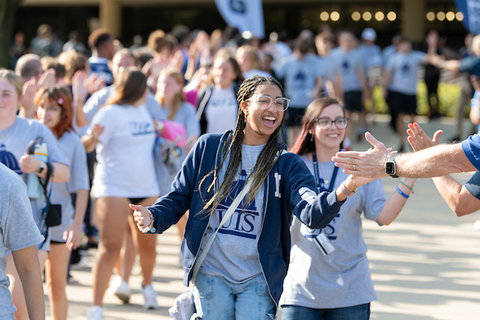 new UIS students giving high fives to a row of UIS staff and faculty