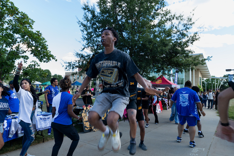 student jumping in the middle of a crowd