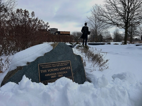 the Young Lawyer plaque and statue in the snow