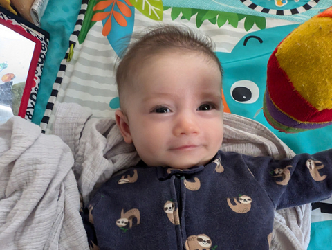 Child reclining on play mat