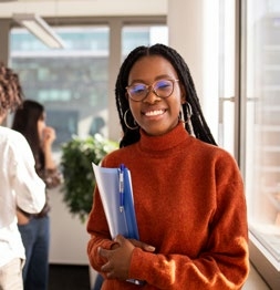 College student holding a folder and pen