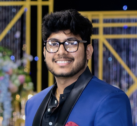 Harsha Chamala head and shoulders in blue jacket and black shirt.