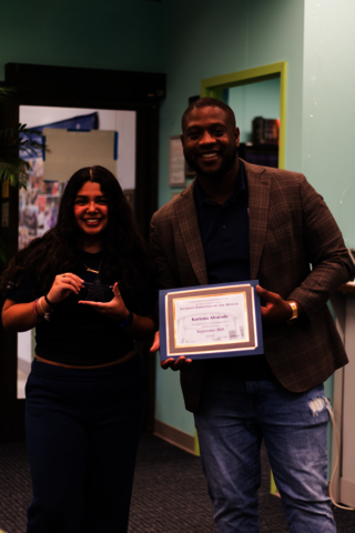 Karizma Alvarado holding her award standing next to Dr. Jamarco Clark