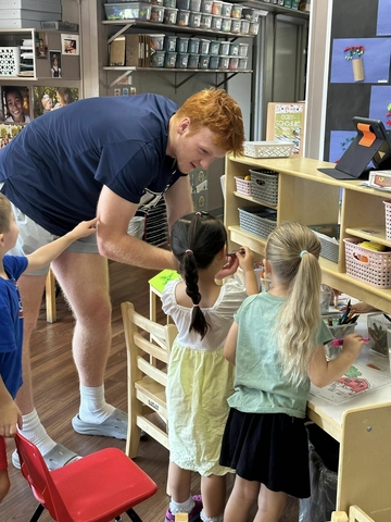 men's basketball team member volunteering in classroom