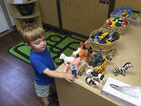 child playing with animal toys