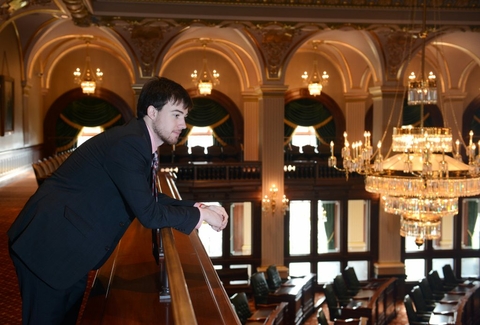 Student looking over state capitol building balcony