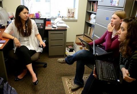 students in a professor's office chatting with each other