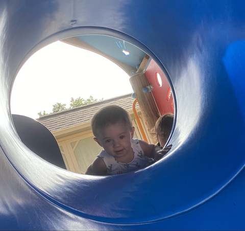 child peering into tunnel