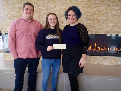 Three Honor Society members holding a check