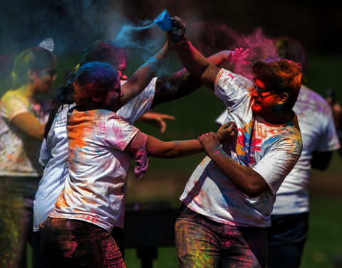Two students fighting to throw blue powder at each other.
