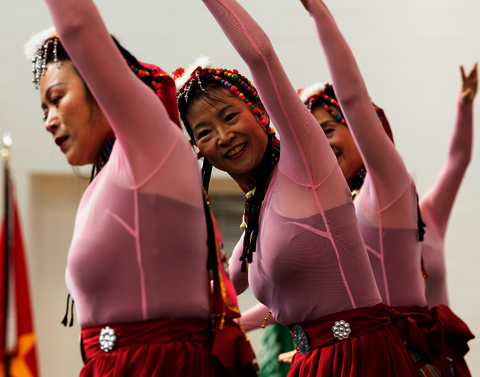 Three Asian women in pink dancing.