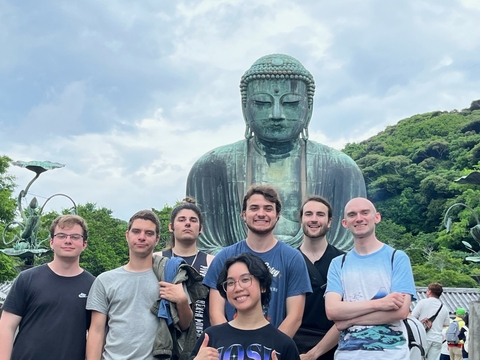 John Linville is pictured with six UIS students during a study abroad trip to Ashikaga, Japan in 2024. Those pictured are standing in front of a statue.