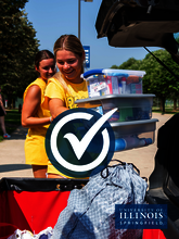 A move-in volunteer is loading boxes into a cart.