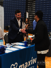 An employer meeting a student at a job fair.