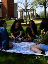 A picture of friends having a picnic on the quad.