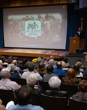 Audience watching the premiere of Soil & Soul at UIS in November 2024, with a speaker at the podium.