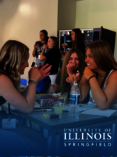 A group of young women are enjoying social time with refreshments and games at the University of Illinois Springfield.
