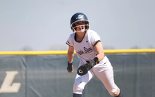Rebecca Neupauer running the bases in white UIS uniform