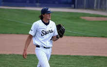 Ben Benoit pitching in white UIS baseball uniform