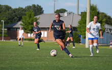 Mallory Herber playing soccer in blue UIS uniform