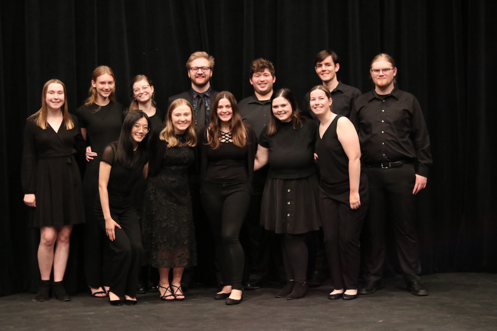 photo of a group of student musicians in front of a black backdrop