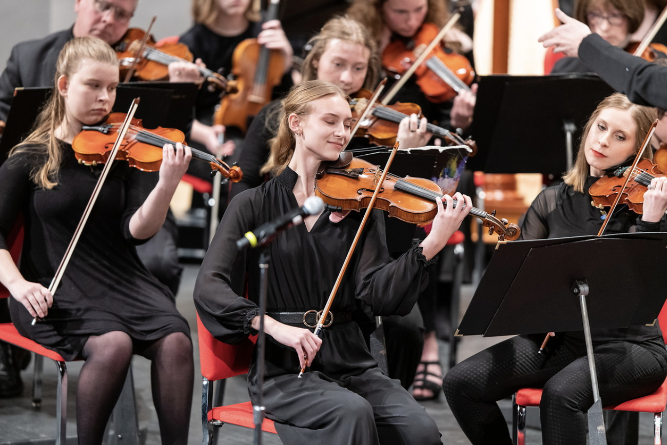 Photo of violin players in an orchestra