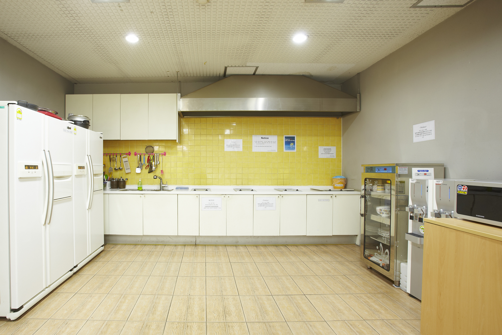 Shared kitchen at SKKU with several refrigerator, a microwave and a couple hot plates on the counter. 
