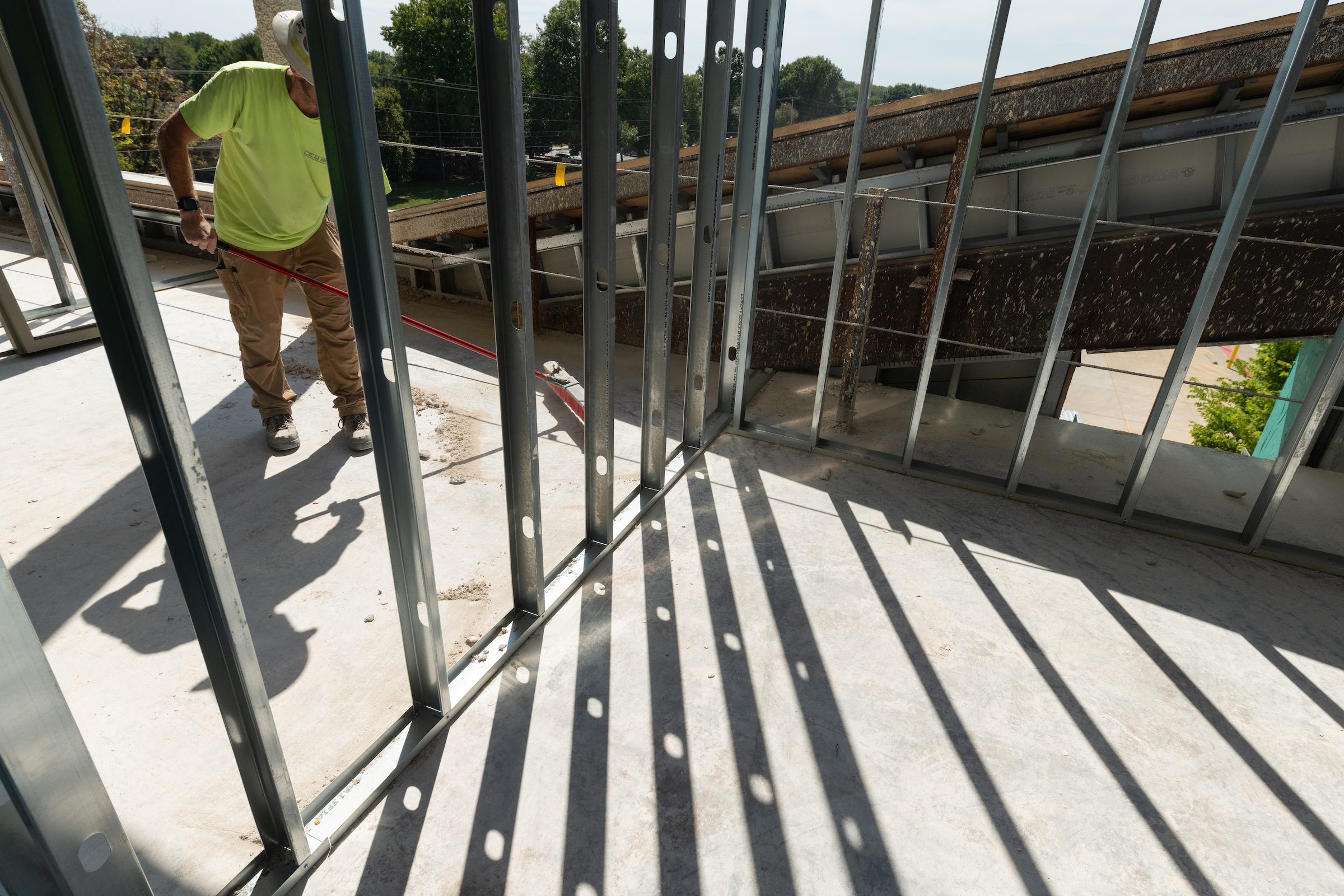 Construction site with metal beams casting shadows.