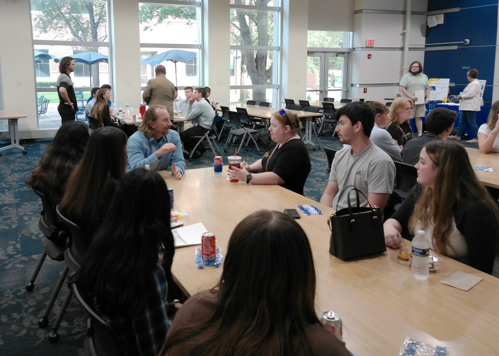 Students and ESP representatives are engaged in discussion, seated at a table.
