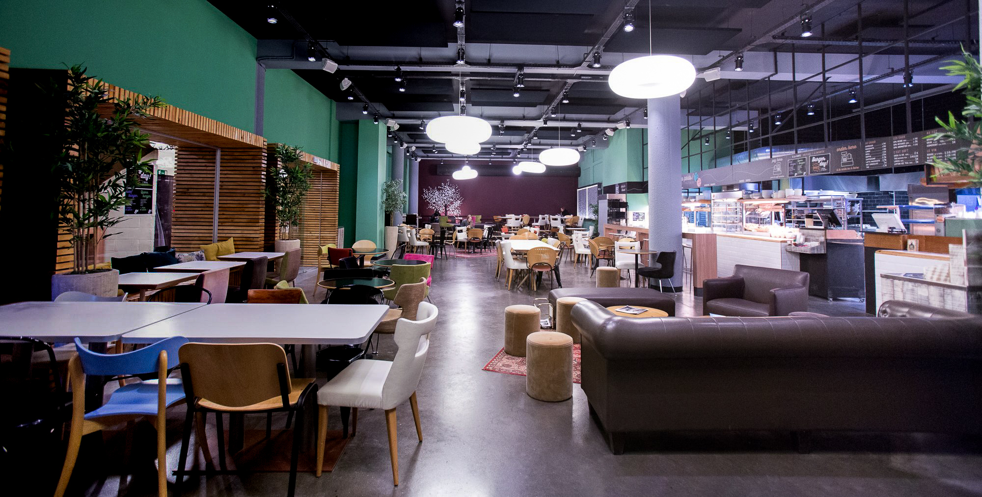 Empty student cafeteria, coffee shop and culture space at IHECS in Belgium. A mixture of chairs and sofas in a cafe environment.