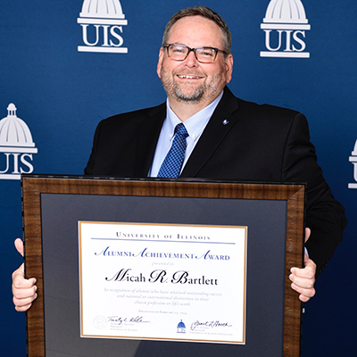 Micah Bartlett holding award