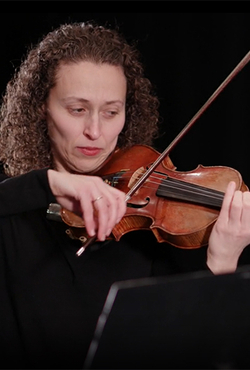 Yona Stamatis playing a violin